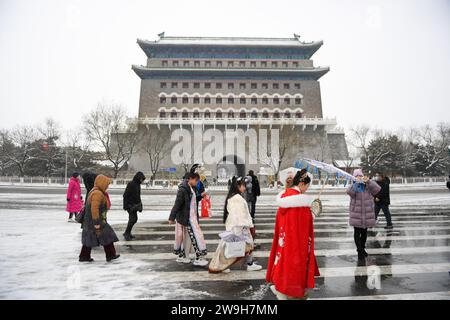 (231228) -- PECHINO, 28 dicembre 2023 (Xinhua) -- la gente cammina di fronte alla torre della freccia della porta di Zhengyang dopo la nevicata a Pechino, capitale della Cina, 14 dicembre 2023. Creato per la prima volta durante la dinastia Yuan (1271-1368), l'asse centrale di Pechino, o Zhongzhouxian, si estende per 7,8 chilometri tra la porta Yongding nel sud della città e la Torre del tamburo e la Torre Campanaria nel nord. La maggior parte dei principali edifici della città vecchia di Pechino si trovano lungo questo asse. Porte, palazzi, templi, piazze e giardini della città vecchia sono tutti collegati all'asse. Mentre assistevano alle attività popolari lungo la linea da o Foto Stock