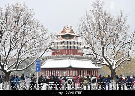 (231228) -- PECHINO, 28 dicembre 2023 (Xinhua) -- i visitatori scattano foto di fronte a una torretta del Museo del Palazzo nella nevicata a Pechino, capitale della Cina, 11 dicembre 2023. Creato per la prima volta durante la dinastia Yuan (1271-1368), l'asse centrale di Pechino, o Zhongzhouxian, si estende per 7,8 chilometri tra la porta Yongding nel sud della città e la Torre del tamburo e la Torre Campanaria nel nord. La maggior parte dei principali edifici della città vecchia di Pechino si trovano lungo questo asse. Porte, palazzi, templi, piazze e giardini della città vecchia sono tutti collegati all'asse. Mentre assistevano alle attività popolari lungo la linea f Foto Stock