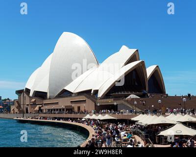 Vista della famosa Sydney Opera House nel porto di Sydney, i corridoi affollati di turisti e visitatori in una luminosa giornata primaverile di novembre Foto Stock