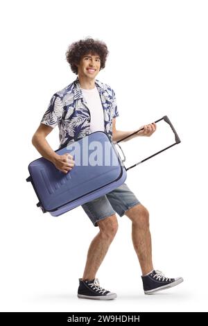 Un giovane felice che finge di suonare una chitarra con una valigia isolata su fondo bianco Foto Stock