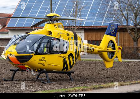 Stettenhofen, Baviera, Germania - 28 dicembre 2023: l'elicottero di salvataggio Christoph 40 dell'ADAC Luftrettung atterra in una zona residenziale durante una missione del medico di emergenza nel villaggio di Langweid OT Stettenhofen *** Rettungshubschrauber Christoph 40 der ADAC Luftrettung Landet bei einem Einsatz vom Notarzt im Dorf Langweid OT Stettenhofen in einer Wohnsiedlung Foto Stock