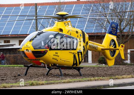 Stettenhofen, Baviera, Germania - 28 dicembre 2023: l'elicottero di salvataggio Christoph 40 dell'ADAC Luftrettung atterra in una zona residenziale durante una missione del medico di emergenza nel villaggio di Langweid OT Stettenhofen *** Rettungshubschrauber Christoph 40 der ADAC Luftrettung Landet bei einem Einsatz vom Notarzt im Dorf Langweid OT Stettenhofen in einer Wohnsiedlung Foto Stock