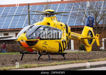 Stettenhofen, Baviera, Germania - 28 dicembre 2023: l'elicottero di salvataggio Christoph 40 dell'ADAC Luftrettung atterra in una zona residenziale durante una missione del medico di emergenza nel villaggio di Langweid OT Stettenhofen *** Rettungshubschrauber Christoph 40 der ADAC Luftrettung Landet bei einem Einsatz vom Notarzt im Dorf Langweid OT Stettenhofen in einer Wohnsiedlung Foto Stock