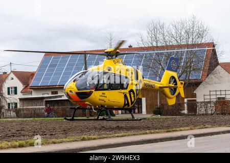 Stettenhofen, Baviera, Germania - 28 dicembre 2023: l'elicottero di salvataggio Christoph 40 dell'ADAC Luftrettung atterra in una zona residenziale durante una missione del medico di emergenza nel villaggio di Langweid OT Stettenhofen *** Rettungshubschrauber Christoph 40 der ADAC Luftrettung Landet bei einem Einsatz vom Notarzt im Dorf Langweid OT Stettenhofen in einer Wohnsiedlung Foto Stock