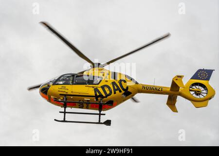 Stettenhofen, Baviera, Germania - 28 dicembre 2023: l'elicottero di salvataggio Christoph 40 dell'ADAC Luftrettung atterra in una zona residenziale durante una missione del medico di emergenza nel villaggio di Langweid OT Stettenhofen *** Rettungshubschrauber Christoph 40 der ADAC Luftrettung Landet bei einem Einsatz vom Notarzt im Dorf Langweid OT Stettenhofen in einer Wohnsiedlung Foto Stock