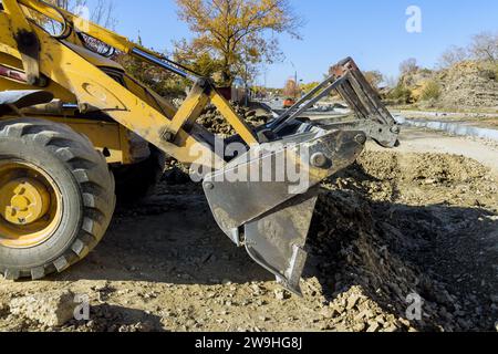 Escavatore per la ricostruzione di autostrade livellando il terreno durante la costruzione di lavori stradali Foto Stock