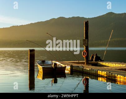 Quinault, Washington - USA - settembre 20.2021: Vista orizzontale di una coppia seduto su un molo al tramonto sul lago Quinault nell'Olympic National Park. Foto Stock