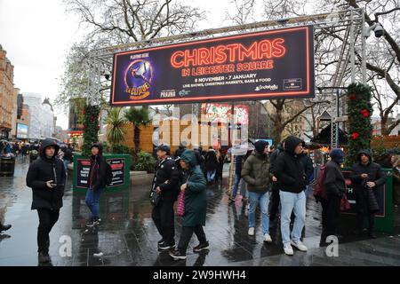 I visitatori hanno apprezzato il mercatino di Natale con le sue bancarelle a Leicester Square nonostante la pioggia. Londra Regno Unito Foto Stock