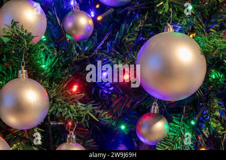 Albero di Natale artificiale con ornamenti e luci - sfondo e texture festivi Foto Stock