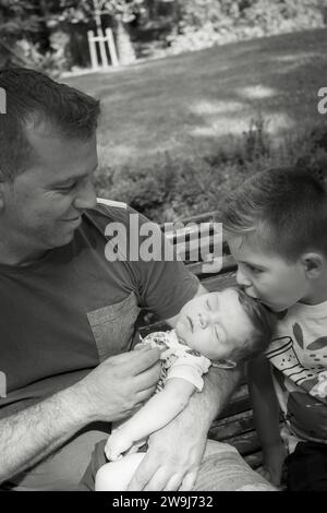 Bambino di quattro anni che bacia suo fratello di due mesi. Dolce scena Foto Stock