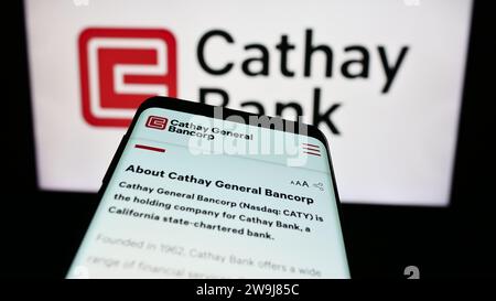 Telefono cellulare con sito web della società statunitense Cathay General Bancorp (Cathay Bank) davanti al logo aziendale. Mettere a fuoco in alto a sinistra sul display del telefono. Foto Stock