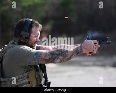 Fayetteville, Stati Uniti d'America. 13 dicembre 2023. L'artista marziale misto Ryan Bader, lancia una pistola contro un bersaglio durante le prove prima di partecipare alla Green Beret Celebrity Tactical Challenge 2023 presso lo U.S. Army John F. Kennedy Special Warfare Center Miller Training Complex di Fort Liberty, 13 dicembre 2023 Fayetteville, North Carolina. Quattordici celebrità hanno collaborato con i Green Berets per partecipare all'evento di tiro annuale. Crediti: K. Kassens/US Army Photo/Alamy Live News Foto Stock