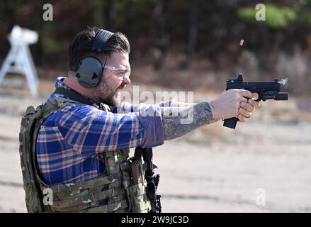 Fayetteville, Stati Uniti d'America. 13 dicembre 2023. L'attore Jack Osbourne lancia una pistola contro un bersaglio durante le prove prima di partecipare alla Green Beret Celebrity Tactical Challenge 2023 presso lo U.S. Army John F. Kennedy Special Warfare Center Miller Training Complex di Fort Liberty, 13 dicembre 2023 Fayetteville, North Carolina. Quattordici celebrità hanno collaborato con i Green Berets per partecipare all'evento di tiro annuale. Crediti: K. Kassens/US Army Photo/Alamy Live News Foto Stock