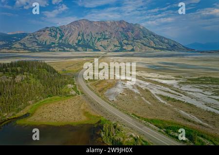 Immagine di un drone, vista dell'Alaska Highway nella Slims River Valley in estate, dietro Sheep Mountain, territorio dello Yukon, Canada Foto Stock