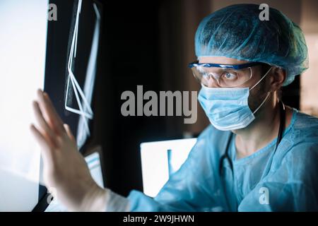 Il chirurgo esamina le immagini fluorografiche su un monitor in una sala operatoria di uno studio medico Foto Stock