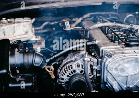 Generatore in un'auto vicino a un motore a combustione interna, riparazione auto Foto Stock