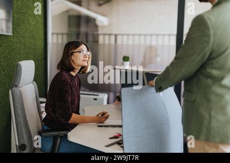 Colleghi che collaborano, fanno brainstorming e risolvono i problemi con energia positiva e creatività. Persone creative che lavorano per il successo. Foto Stock