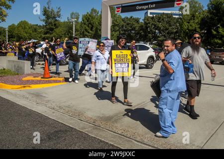 Alla ricerca di un nuovo contratto di lavoro, i dipendenti di assistenza sanitaria multirazziale marciano in segno di protesta durante uno sciopero in una struttura HMO Kaiser permanente a Irvine, C. Foto Stock