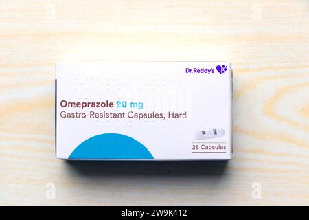 Dr Reddys 20mg omeprazolo capsule gastro-resistenti per il trattamento di bruciore di stomaco reflusso acido e indigestione in scatola isolata su fondo di legno Foto Stock
