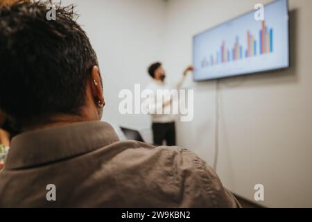 Professionisti aziendali in una riunione di Consiglio di amministrazione, analizzando le statistiche e discutendo idee per la crescita e la redditività. Foto Stock