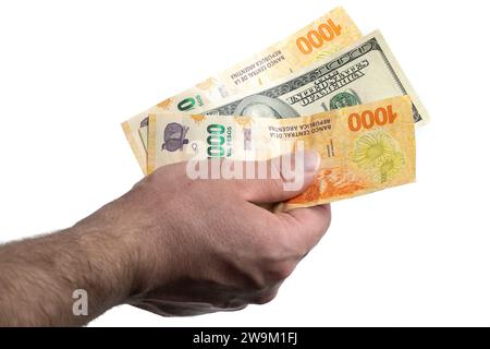 Mano con banconote argentine e da dollari. Foto Stock