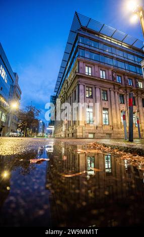 Stoccarda, Germania. 29 dicembre 2023. L'edificio della Borsa di Stoccarda si riflette in una pozzanghera all'ora blu del mattino. Nonostante tutte le incertezze, la Borsa di Stoccarda ha mantenuto la sua attività stabile nel 2023. (A dpa: "Scambi di affari alla Borsa di Stoccarda stagnates") credito: Christoph Schmidt/dpa/Alamy Live News Foto Stock