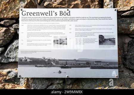 Un segno esplicativo sui resti del BOD di Greenwell, o stand a Uyeasound su Unst. Risale al 1640 ed era un negozio e magazzino anseatico. Foto Stock