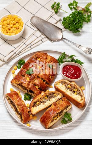 Colazione con salsiccia italiana, treccia con uova strapazzate, mais, formaggio cheddar su piatto con salsa di pomodoro e prezzemolo su tavola di legno bianco, vie verticali Foto Stock