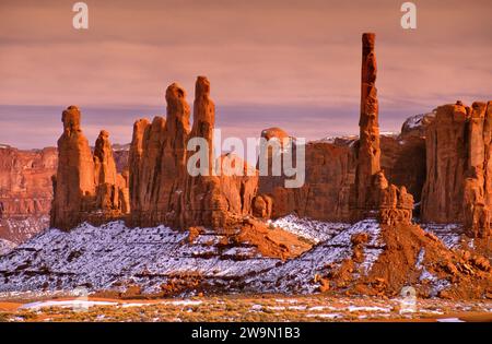 Totem Pole (a destra), altre guglie rocciose nella Monument Valley, al tramonto dopo la tempesta di neve in inverno Foto Stock