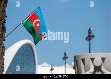 Bandiera nazionale dell'Azerbaigian con il centro congressi Heday Aliyev sullo sfondo. Foto Stock