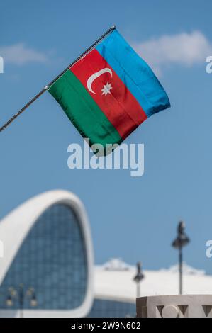 Bandiera nazionale dell'Azerbaigian con il centro congressi Heday Aliyev sullo sfondo. Foto Stock