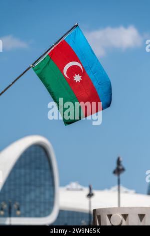 Bandiera nazionale dell'Azerbaigian con il centro congressi Heday Aliyev sullo sfondo. Foto Stock