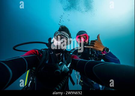 I subacquei che scattano selfie durante una sosta di sicurezza ad Alor / Indonesia Foto Stock