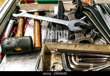 Cassetta per utensili in legno con chiavi vecchie e sporche, arrugginite, chiavi ad anello, pinze, cacciaviti. Foto Stock