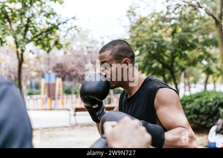 uomo che lotta proteggendo il suo viso all'aperto Foto Stock