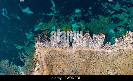 Sicilia 2023. Vista aerea della costa rocciosa, dove il mare calmo e cristallino si adatta alla città di Macari. Luglio 2023 Trapani, Italia Foto Stock