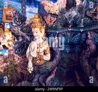 Mitico idolo in legno intagliato a mano all'interno del Tempio Blu Wat Rong Suea Ten a Chiang Rai Thailandia Foto Stock
