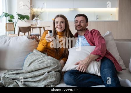 Amore, romanticismo nella giovane famiglia. Trascorri i fine settimana insieme a casa, guardando film divertenti in TV Foto Stock