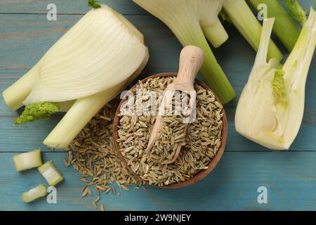 Semi di finocchio in recipiente, verdure fresche e paletta su un tavolo di legno azzurro, a posa piatta Foto Stock