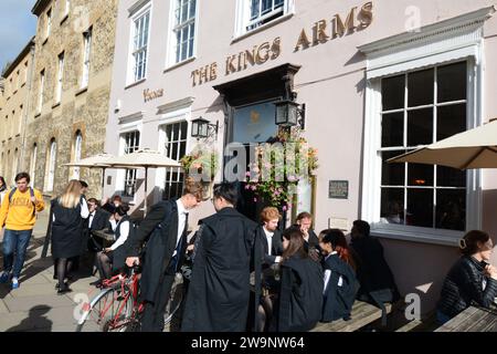 Studenti di Oxford, ragazzi, ragazze, camici, camici, camminate per ammirare panorami fuori dalla vecchia storia, un luogo storico dove mangiare bere cibo da pub e bar Foto Stock