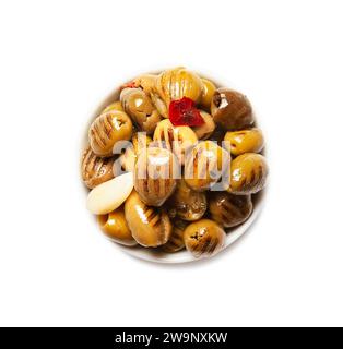 Olive verdi grigliate in olio, snocciolate, con pepe rosso caldo e aglio, isolate Foto Stock