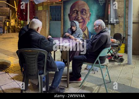 Gli uomini ebrei anziani giocano le carte nel mercato di Mahane o Machane Yehuda spesso indicato come 'The Shuk', un mercato all'aperto, a Gerusalemme ovest, Israele Foto Stock