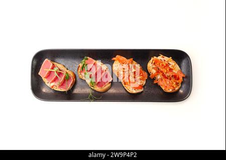 Bruschetta con tartare di salmone e tonno su pane tostato di ciabatta isolato Foto Stock