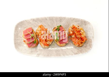 Bruschetta con tartare di salmone e tonno su pane tostato di ciabatta isolato Foto Stock