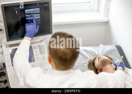 Uomo durante una diagnosi ecografica dell'arteria carotide Foto Stock