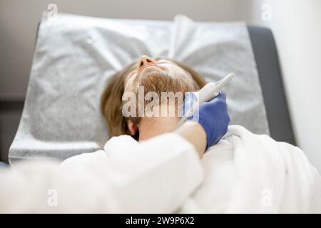 Uomo durante una diagnosi ecografica dell'arteria carotide Foto Stock