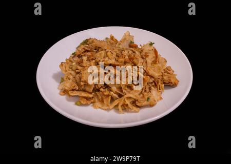 Kottu roti dello Sri Lanka su un piatto bianco su sfondo nero Foto Stock