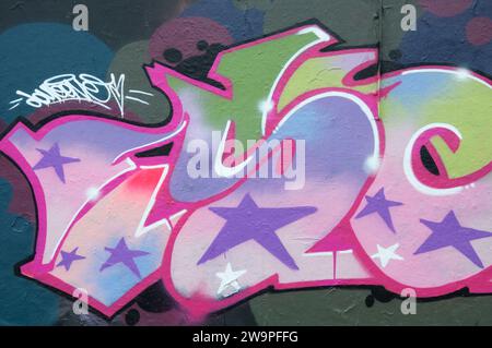 Street art urbana. Colorate lettere di graffiti e stelle, dipinte su un muro sotto il cavalcavia Fleetsbridge a Poole. Dorset, Inghilterra, Regno Unito, Regno Unito. Foto Stock