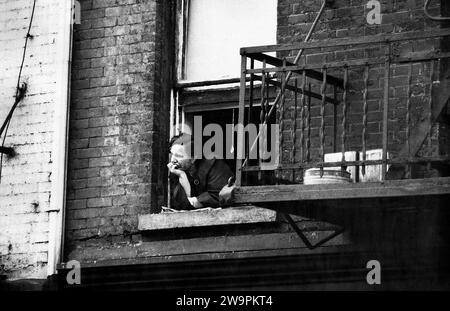 Donna che si piega fuori dalla finestra dell'edificio, New York City, New York, USA, Angelo Rizzuto, Anthony Angel Collection, settembre 1953 Foto Stock