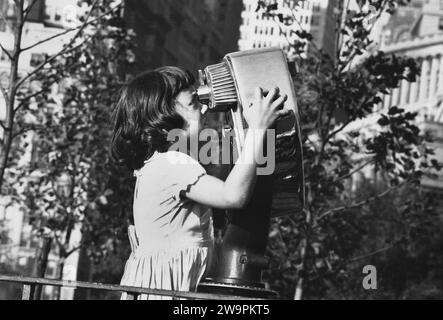 Giovane ragazza che guarda attraverso un binocolo di osservazione a gettoni, New York City, New York, USA, Angelo Rizzuto, Anthony Angel Collection Foto Stock